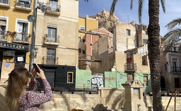 Una turista hace una foto con su móvil del Castillo de Santa Bárbara desde la plaza Quijano