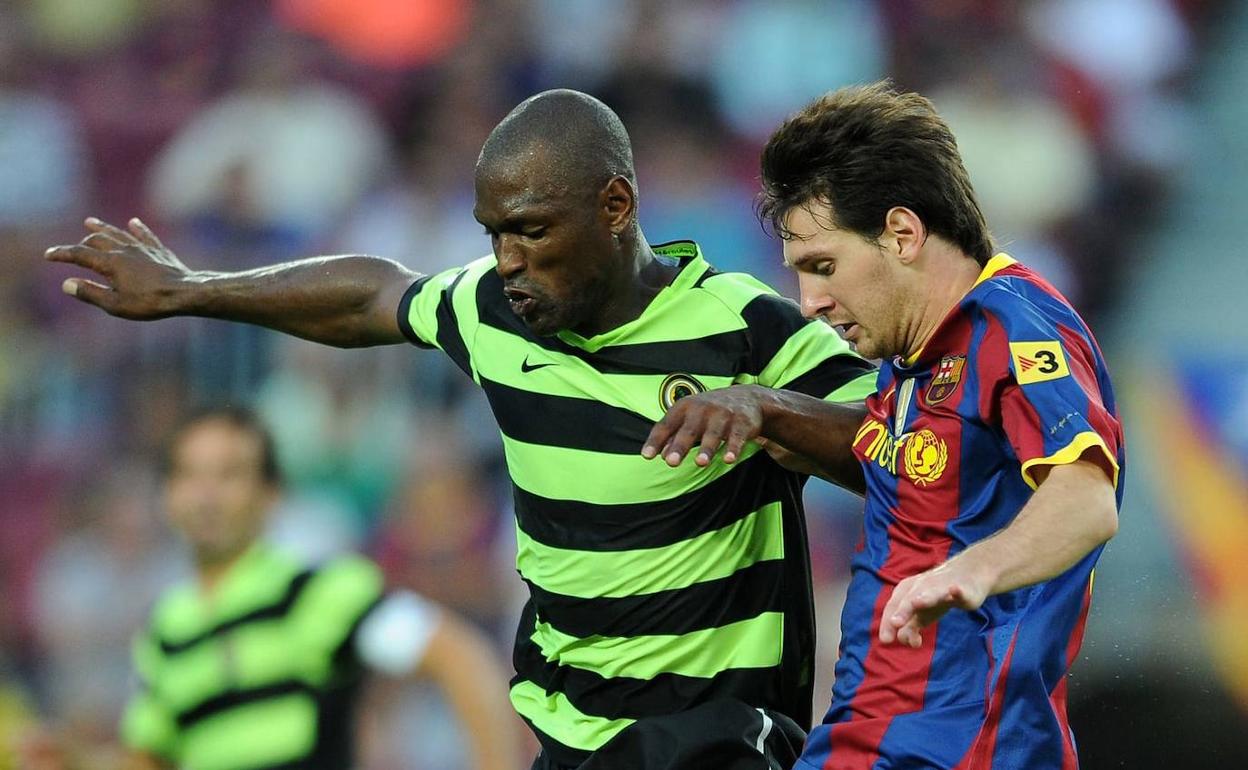 Noe Pamarot pelea por la posición con Messi en el Camp Nou en 2010. 