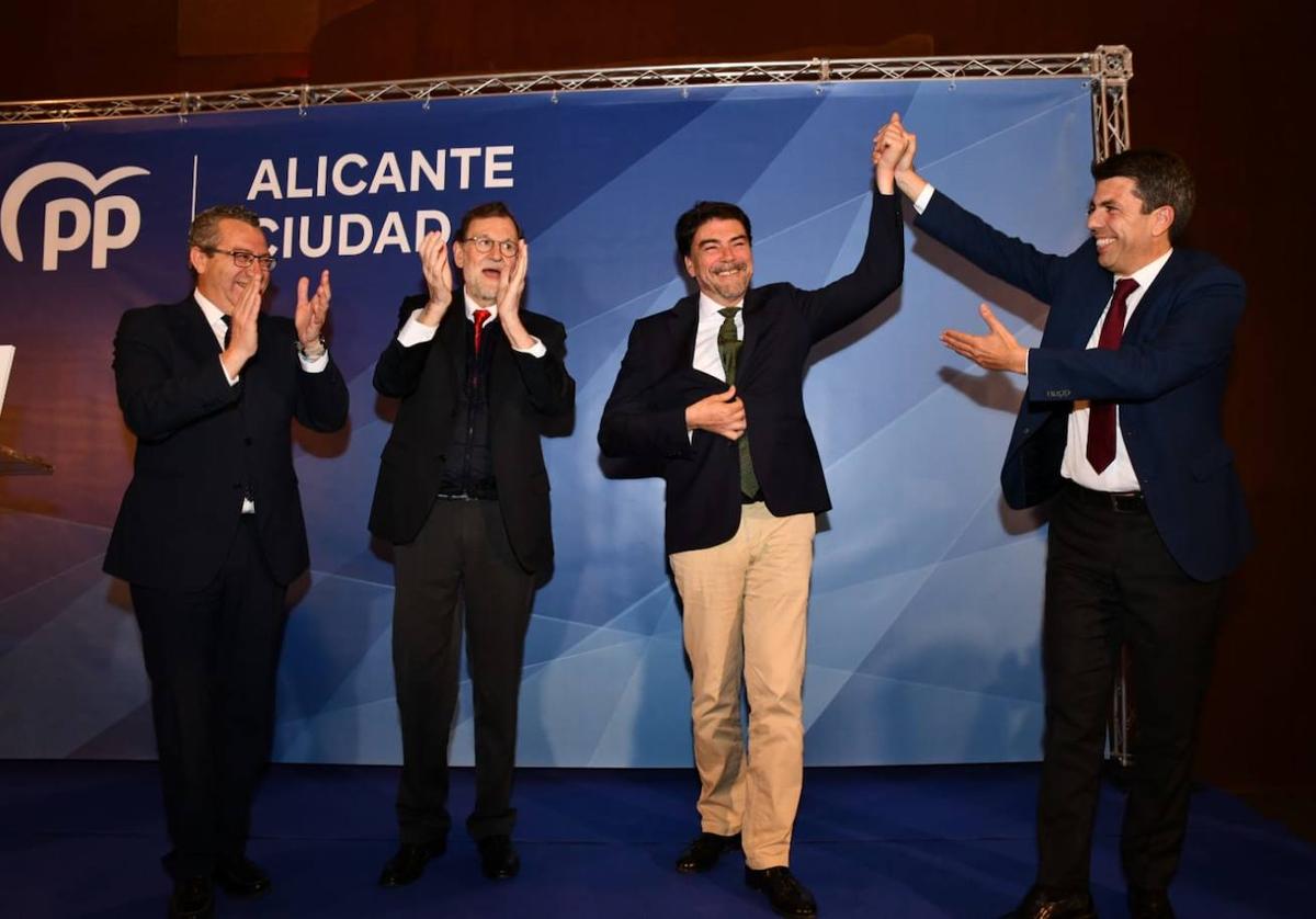 El presidente del PPCV, Carlos Mazón, levanta el brazo del alcalde de Alicante, Luis Barcala, en presencia del presidente del PP provincial, Toni Pérez, y del expresidente Mariano Rajoy.