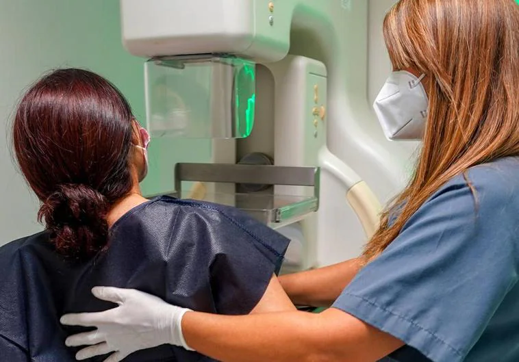 Una mujer somitiéndose a una mamografía