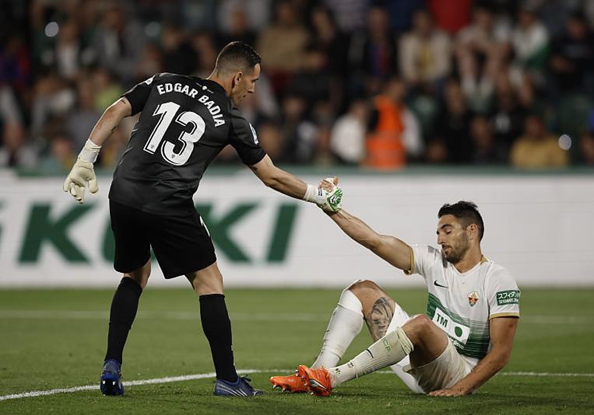 Edgar Badía ayuda a levantarse al central Pedro Bigas en el partido ante el Barcelona