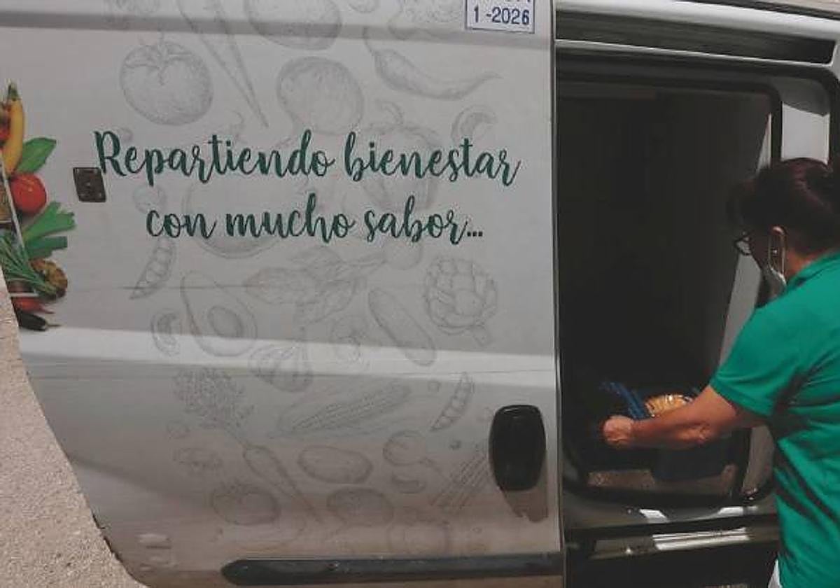 Una de las trabajadoras de este servicio repartiendo la comida
