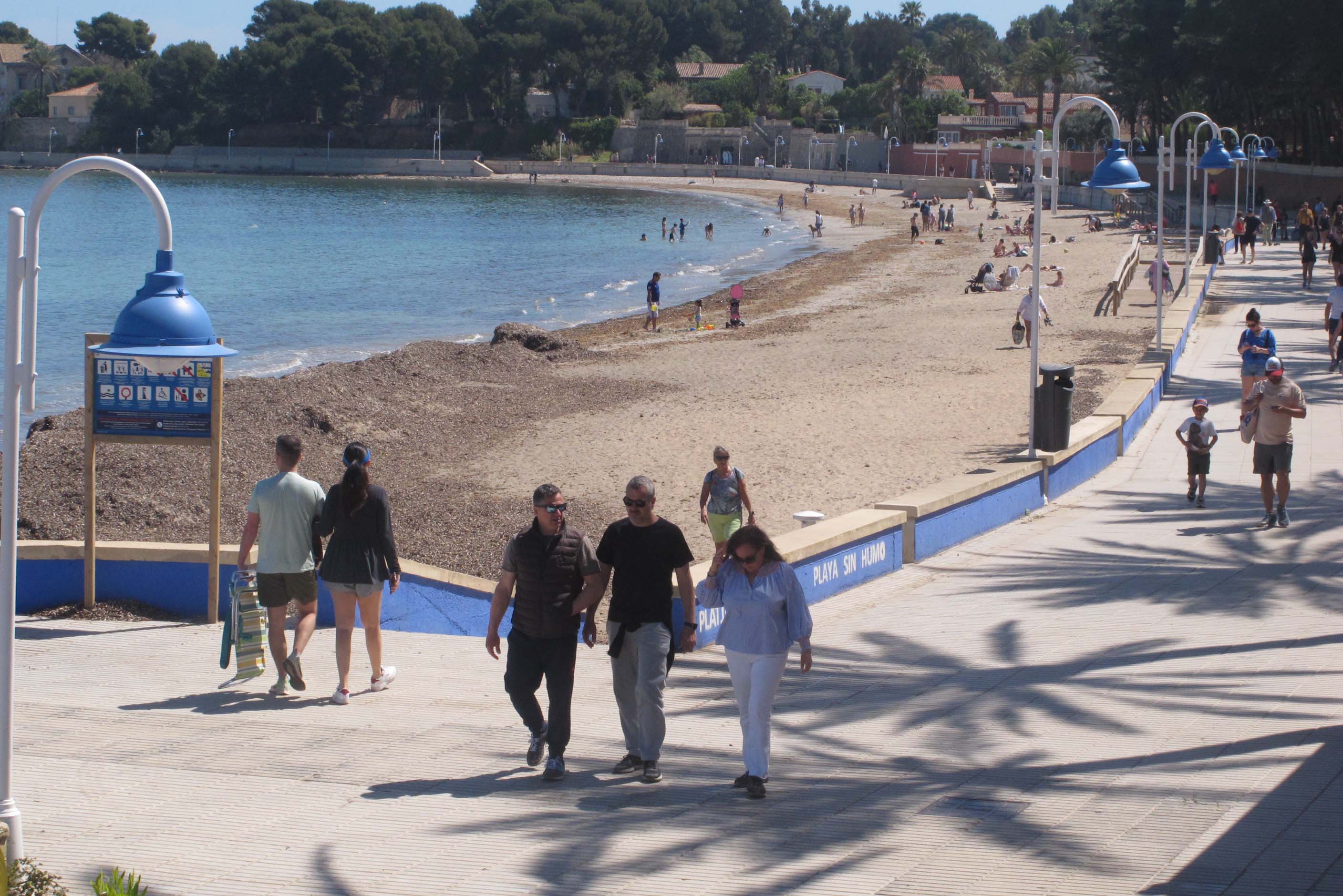 Paseantes por la playa de Dénia.