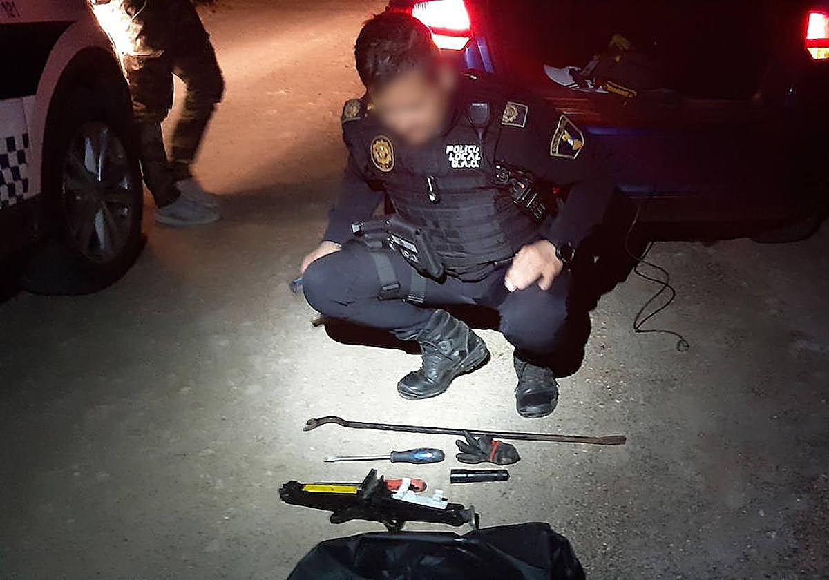 Un agente observa las herramientas encontradas en el vehículo sospechoso.