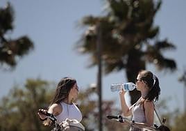Dos jóvenes se refrescan mientras hacen ejercicio.
