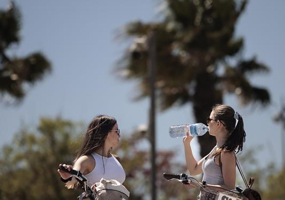 Dos jóvenes se refrescan mientras hacen ejercicio.