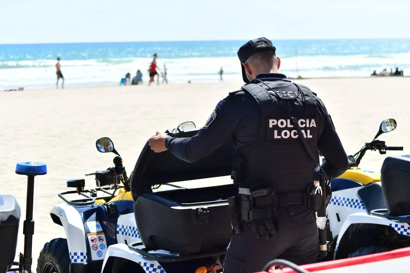 Un policía local revisa su quad, en la Playa de San Juan.