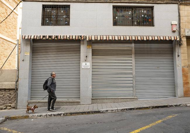 Una persona pasea por Colonia Requena frente a un bar cerrado