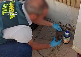 Un agentte inspecciona una cerradura inutilizada con el compuesto químico corrosivo.