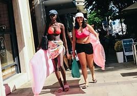 Dos turistas, de vuelta del Postiguet, por la Rambla.