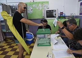 Un hombre cargado con nevera y sombrilla de playa ejerce su derecho al voto