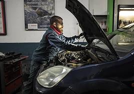 Un mecánico revisa el motor de un coche