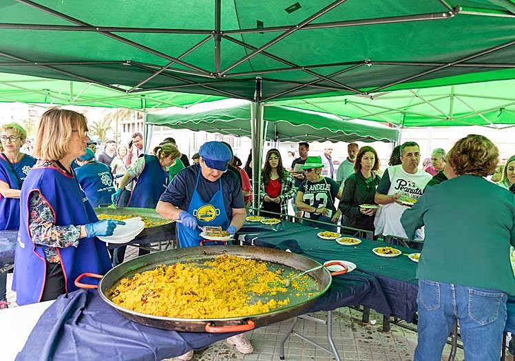 Imagen principal - Asistentes al evento disfrutando de la paella y presencia del alcalde y la edil de Fiestas. 