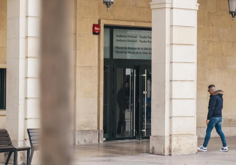 Un hombre pasa por la puerta de la Audiencia Provincial de Alicante.
