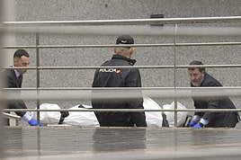 Operarios de una funeraria trasladan el cadáver de una de las dos niñas.