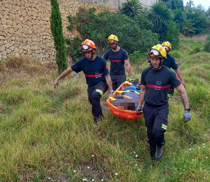 La mujer siendo rescatada por cuatro bomberos.