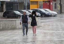 Dos personas bajo la lluvia.