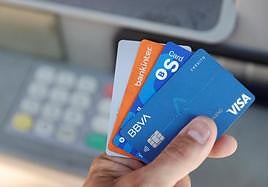 Una persona muestra diferentes tarjetas de crédito.