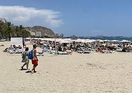 Turistas disfrutan en la playa del Postiguet