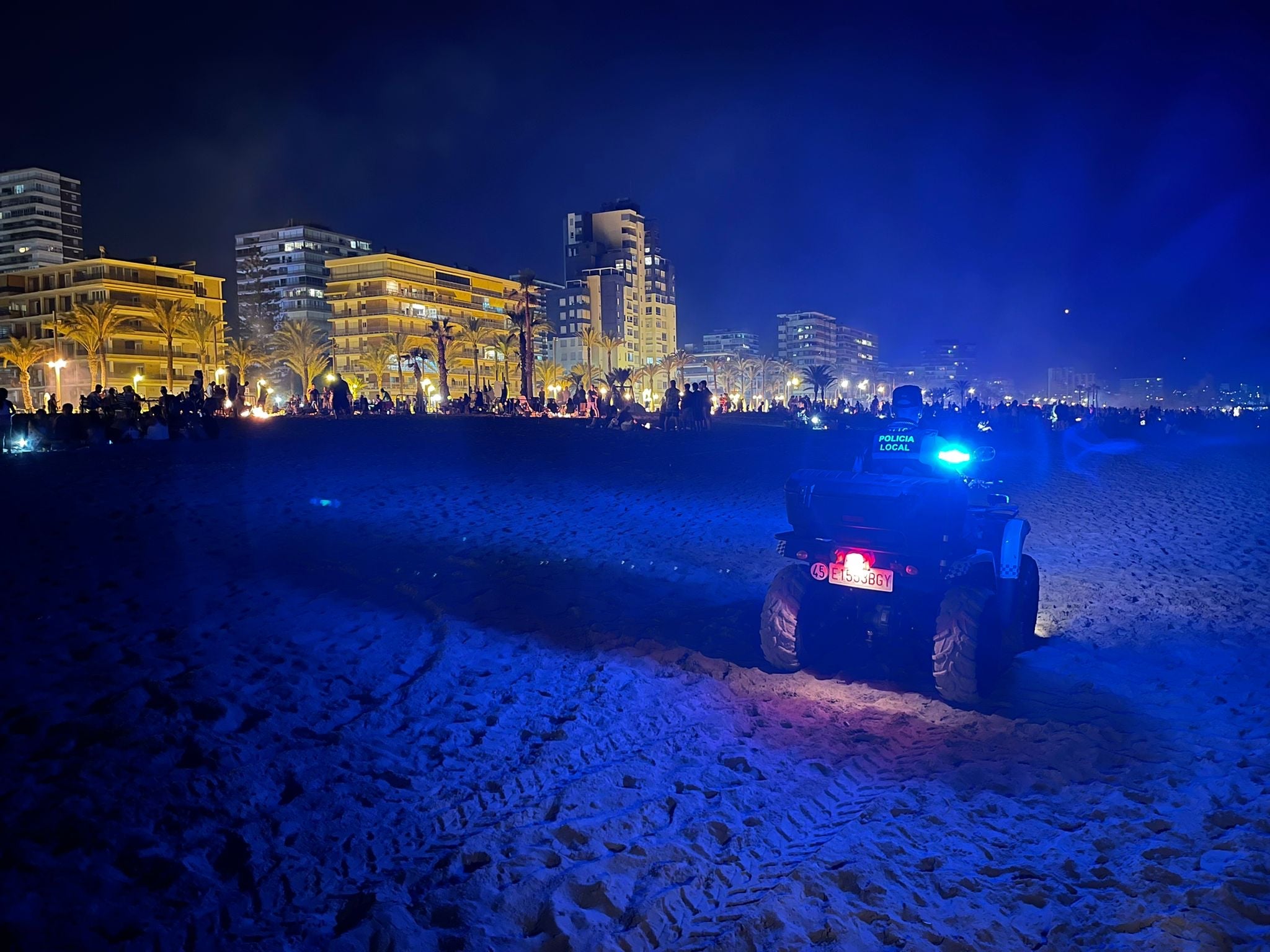 Un agente patrulla por la playa con un quad.