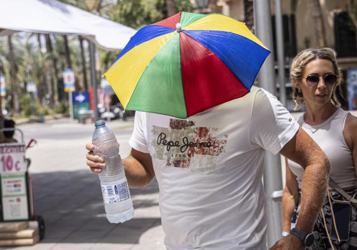 Un hombre con un gorro con sombrilla durante la ola de calor.