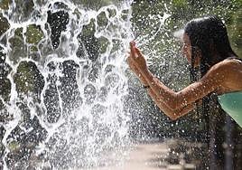 Una persona se refresca en una fuente