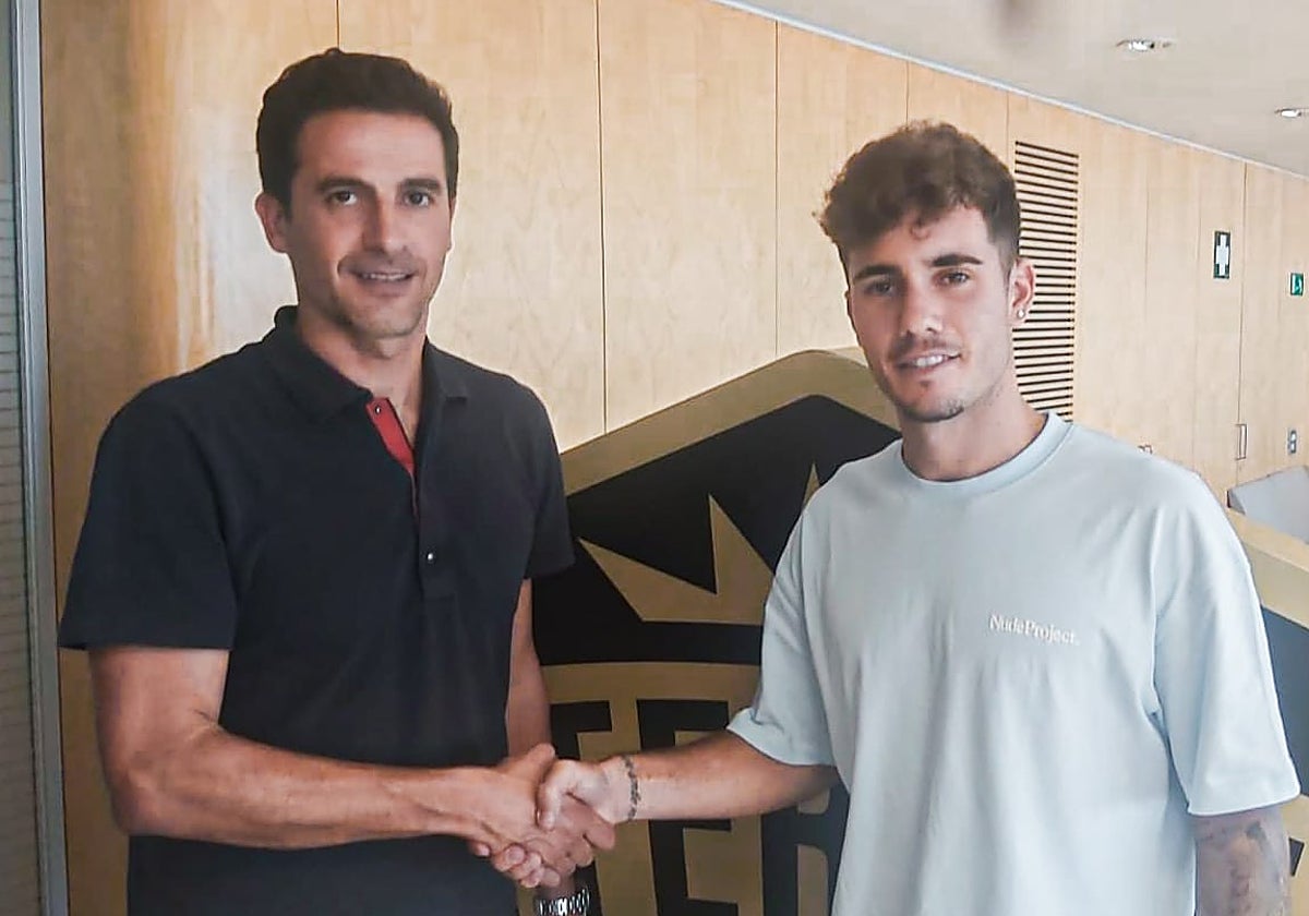 El director deportivo Jorge López estrecha la mano del delantero Simón