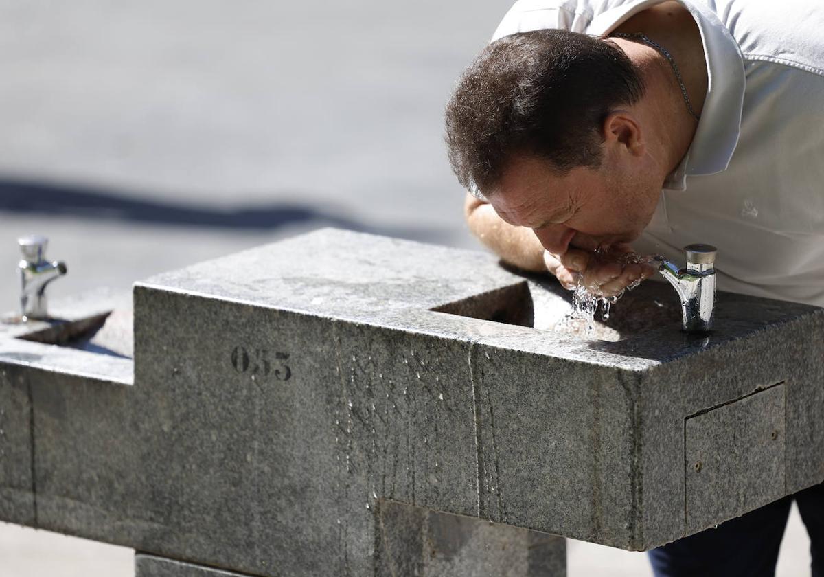 Un ciudadano bebe de una fuente ante el intenso calor.