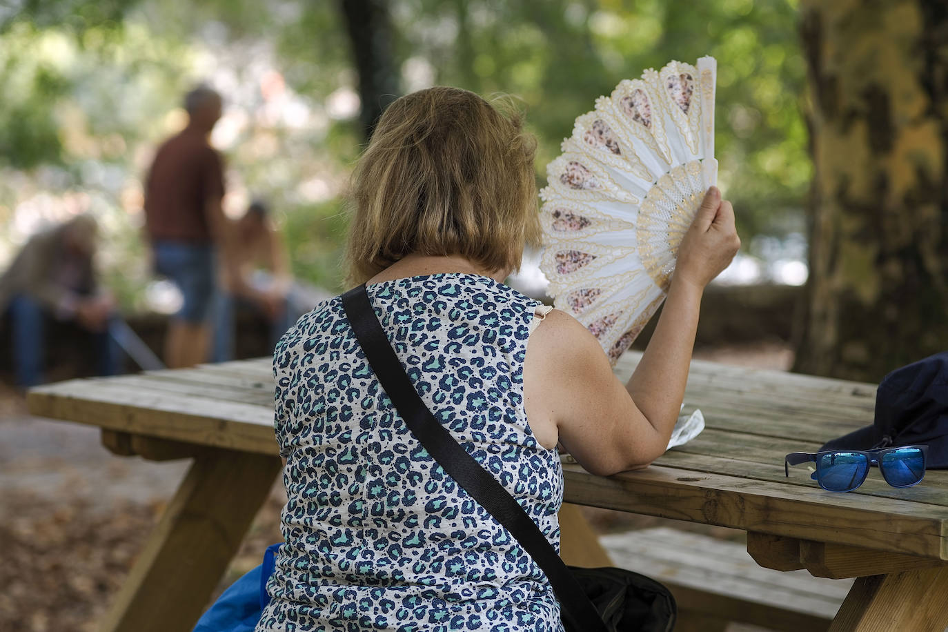 Una mujer se abanica ante el intenso calor de este verano.