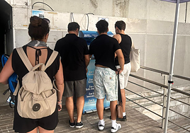 Varios turistas esperan en las fuentes de agua recién instaladas.