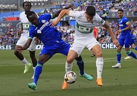 Lautaro Blanco protege el balón ante Djené la temporada pasada