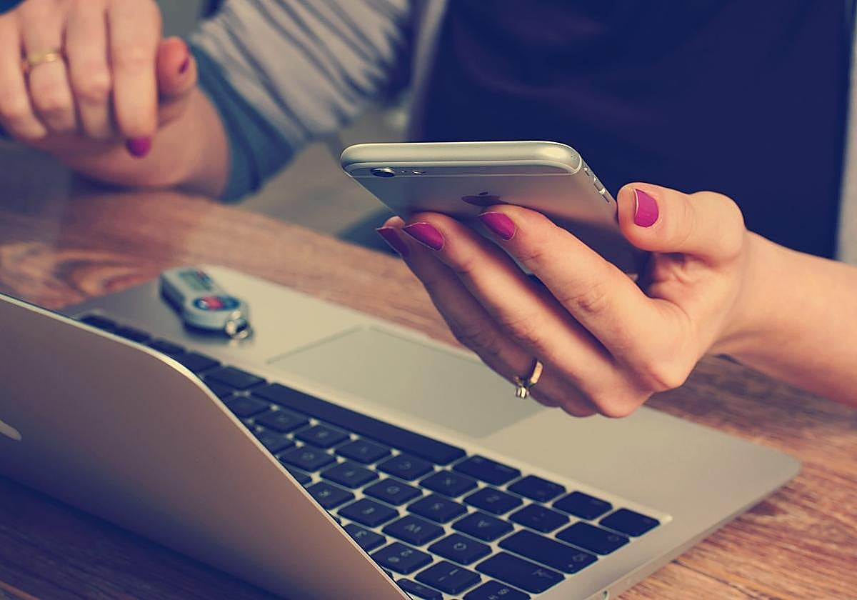 Una mujer usa un teléfono móvil.