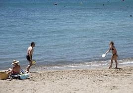 Dos personas juegan a las palas en una playa de Alicante.