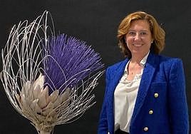 La alcaldesa de Almoradí, María Gómez, posa con un monumento dedicado a la alcachofa, emblema de la localidad.