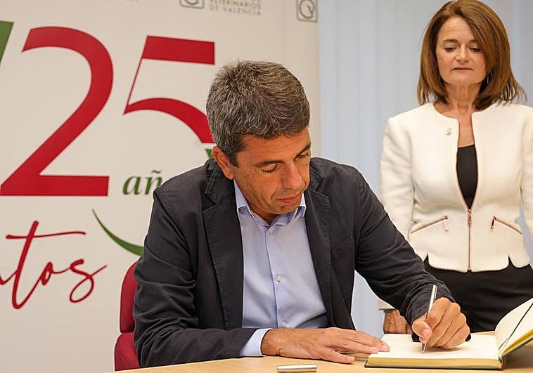 El presidente, Carlos Mazón, firma en el libro de honor del Colegio de Veterinarios.