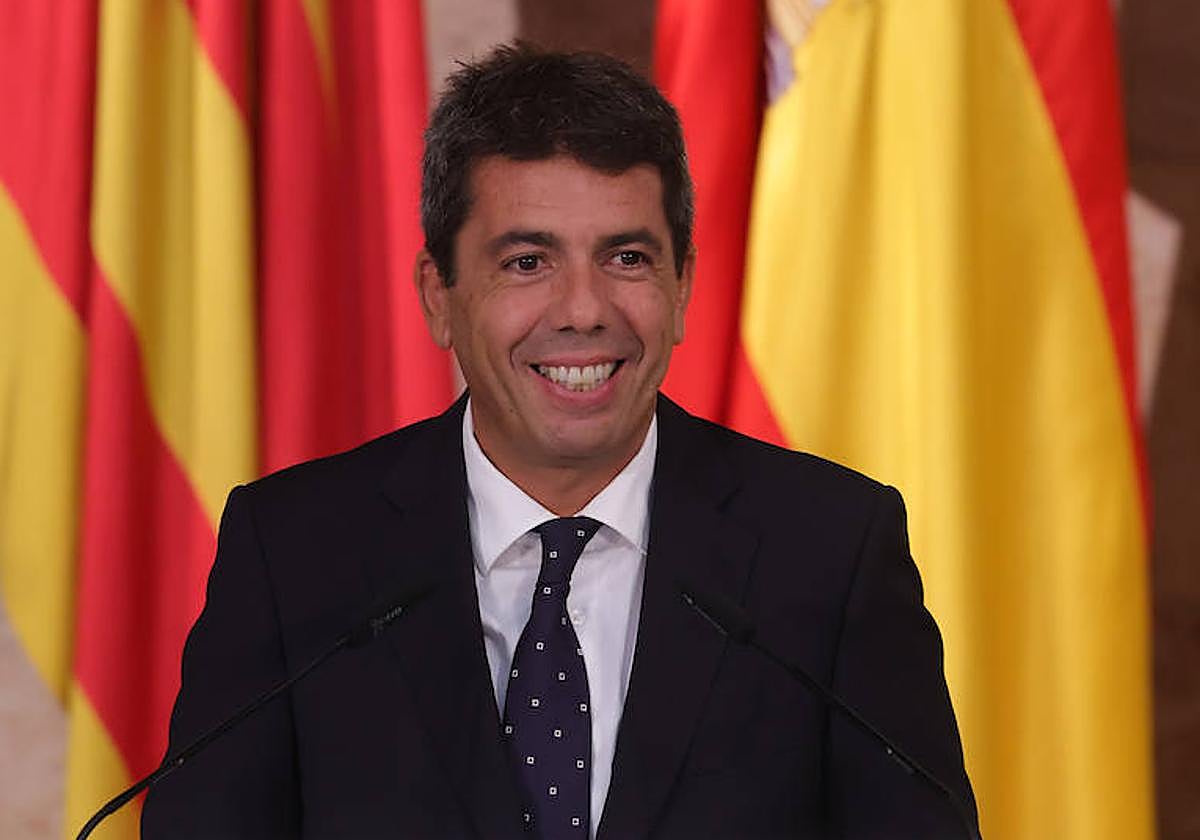 El presidente de la Generalitat Valenciana, Carlos Mazón, con las banderas española y de la Comunitat Valenciana.