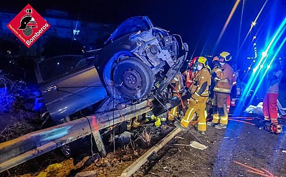 Los bomberos trabajan en uno de los coches implicados en el accidente.