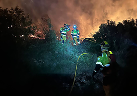 Los bomberos contienen las llamas del incendio.