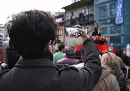 Un hombre graba una procesión con su móvil.