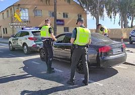 Los agentes de la Benemérita con el vehículo sospechoso.
