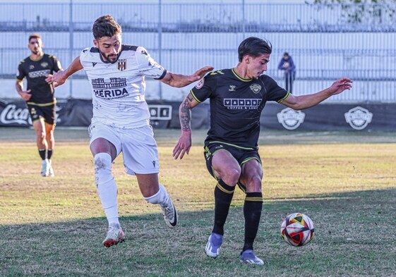 Cristo Romero controla un balón ante un rival del Mérida en el maltrecho terreno de juego.