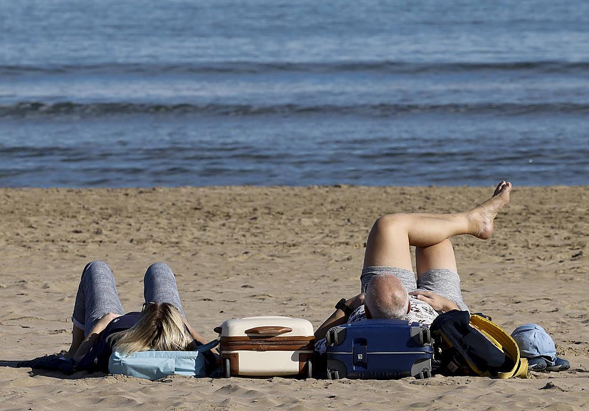 Dos personas disfrutan del buen tiempo en la playa.