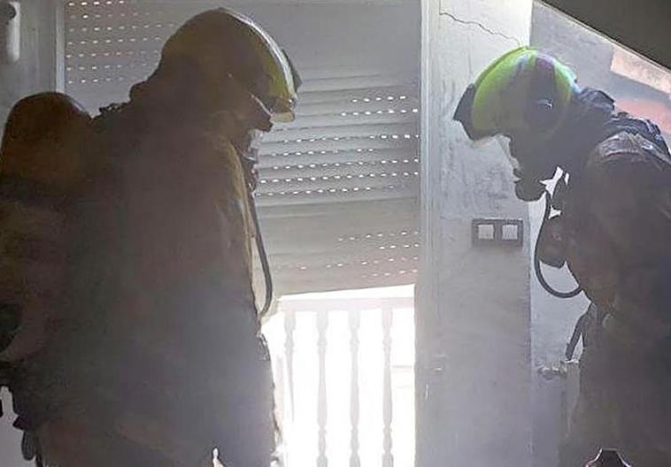 Los bomberos en el interior de la vivienda siniestrada.