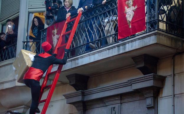 Uno de los pajes sube a los balcones de Alcoi para entregar un regalo.