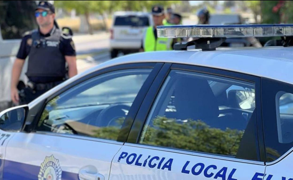 Coche y agentes de la Policía Local de Elche. 