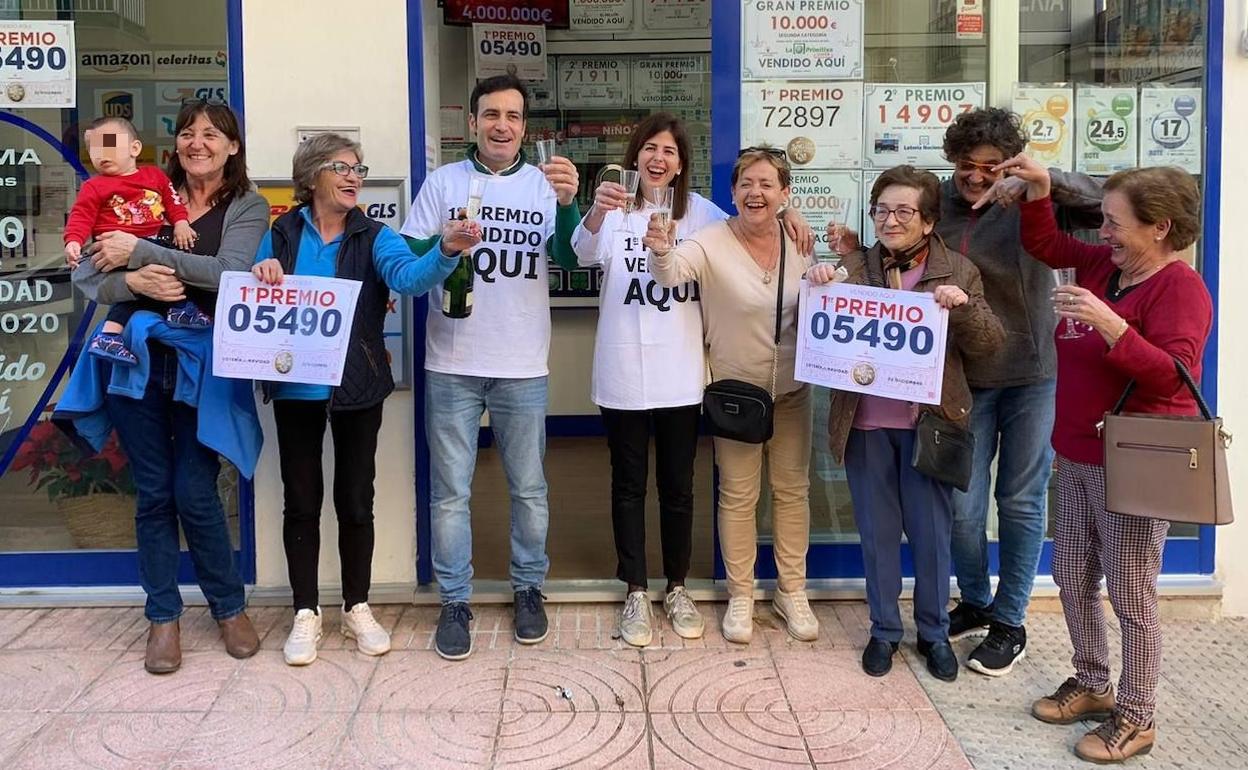 Víctor, con clientes y amigos celebrando el Gordo de Navidad 2022 repartido en su administración. 