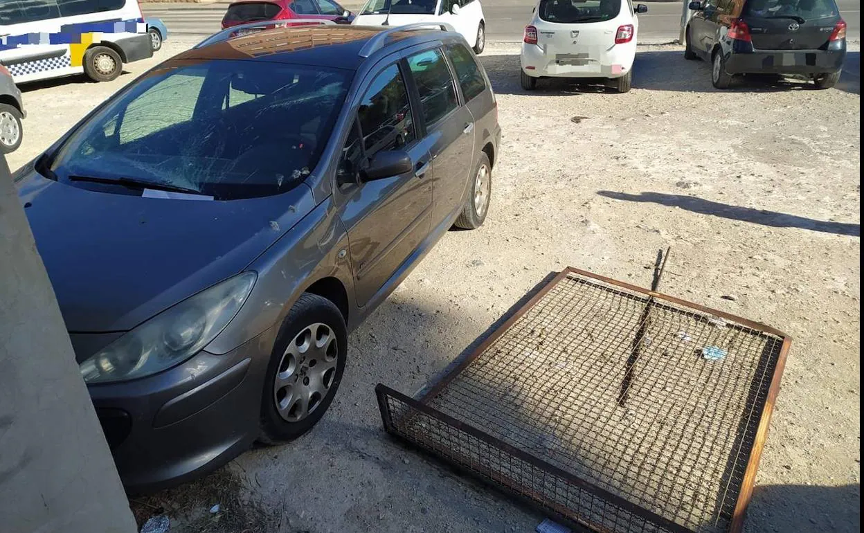 Imagen de la verja desprendida y el desperfecto causado en el coche