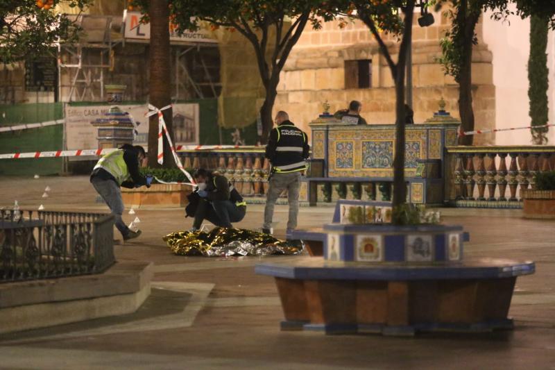 Una persona yace bajo una manta térmica la Plaza Alta de Algeciras tras el ataque.