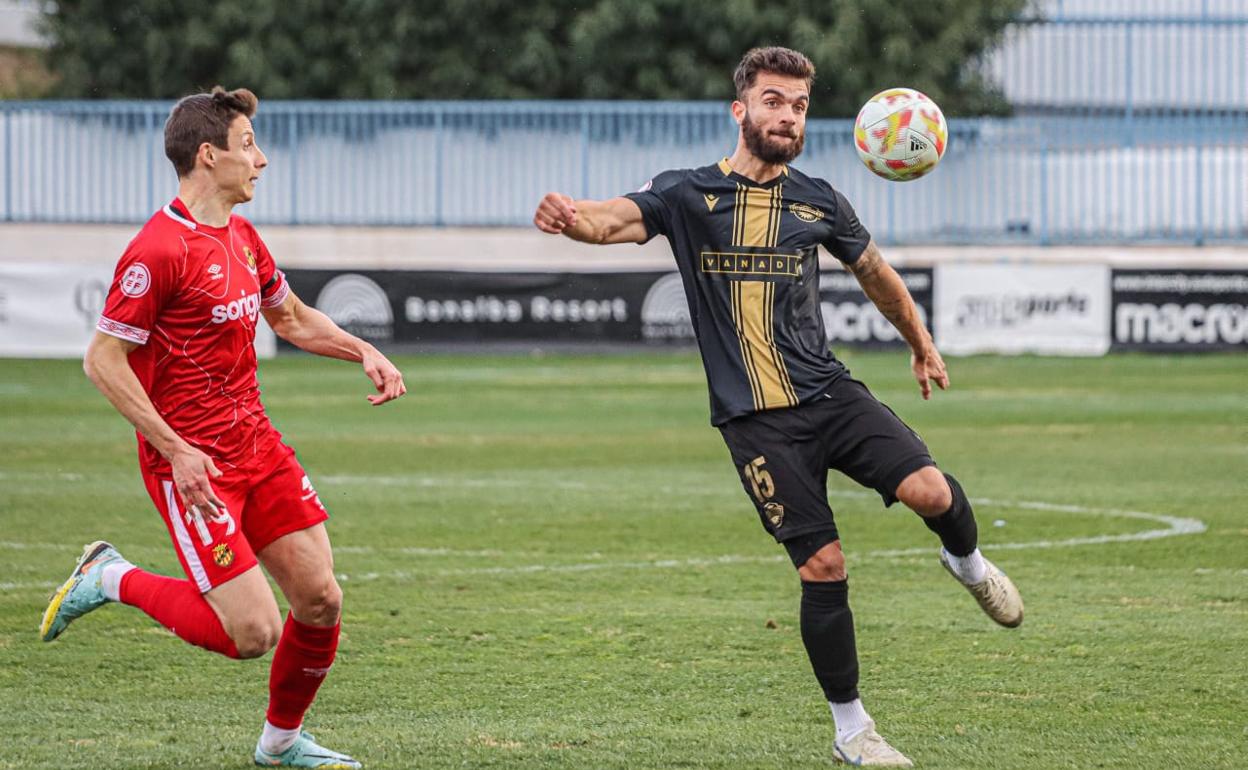 El central del Intercity Álvaro Pérez despeja un balón ante la presencia de un rival. 