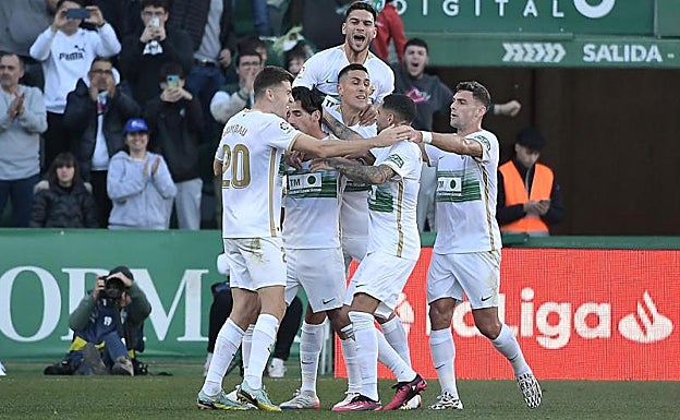 Piña de jugadores del Elche abrazando a Pere Milla 